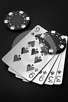 Black chips and playing cards with a winning combination of two pairs. The concept of luck or fortune in a poker club