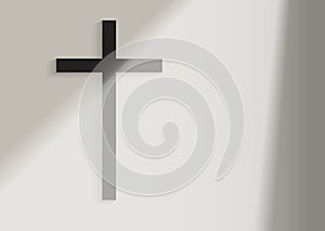 Black Christian Cross on the white wall background with window light and shadow