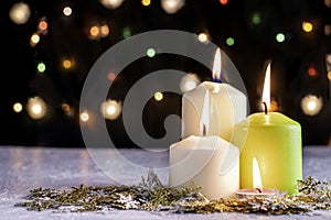 black Christmas background with colorful lights burning candles and decorative snowflakes in the foreground