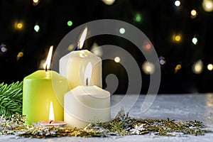 black Christmas background with colorful lights burning candles and decorative snowflakes in the foreground