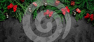 Black Christmas Background. Framed by Christmas Tree Branches and Red Decoration Banner. Empty Space