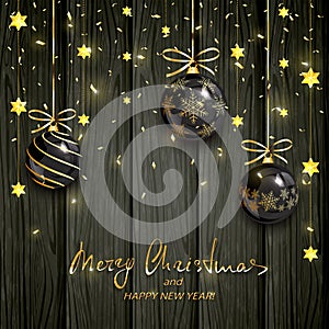 Black Christmas balls and gold stars on wooden background