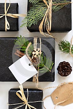 Black Christmas present with blank square gift tag, with fir branch and decorations, Mockup