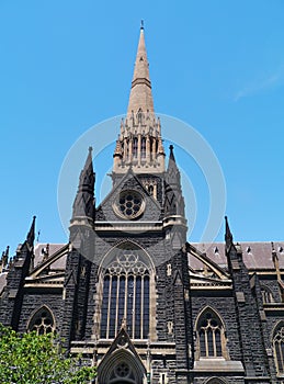 A black church opposite a blue sky