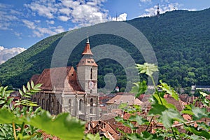 Landmark attraction in Brasov, Romania. Old town. The catholic Black Church (Biserica Neagra) and Tampa mountains photo