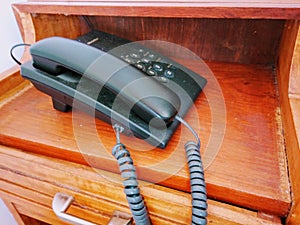 Black clasic telephone on wooden desk photo