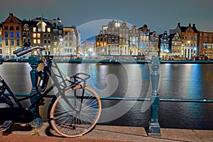 View to historic houses and bike at night in Amsterdam