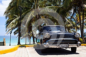 A black classic car parked near the beach