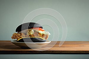 Black Classic Chicken burger on wood table with copy space and w