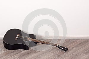 Black Classical Acoustic Guitar in an Empty Room lying on floor