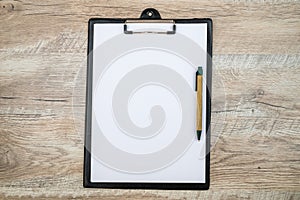 Black clipboard with blank white sheet and pen