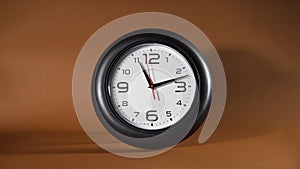 Black Clock is Ticking on the Brown Background