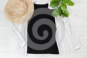 Black closeup t shirt mock up flat lay on white wooden background. Top view and copy space. Mockup t-shirt and summertime.