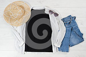 Black closeup t shirt mock up flat lay on white wooden background. Top view and copy space. Mockup t-shirt and summertime.