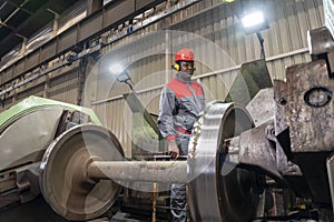 Black CNC Machine Operator Monitoring The Train Wheel Manufacturing Process On Lathe Machine In A Train Factory