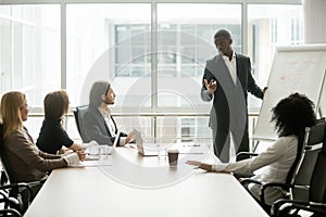 Black coach giving presentation to clients at conference meeting