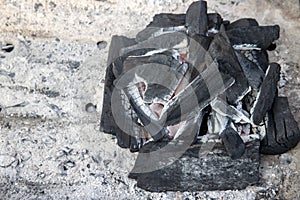 Black coal with flame closeup photo on ash background. Coal pile closeup photo. Cooking grill on coal concept