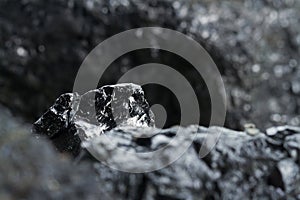 Black coal mine close-up with soft focus. Anthracite coal bar on dark background. Natural black coal bars for background.