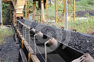 Black coal passes above the conveyor belt