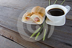 Black coffee with Bread stuffed with Sausage on a wood backgroun