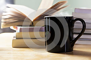 Black coffee cup and book pile