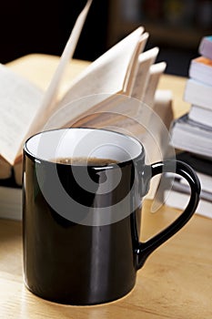 Black coffee cup and book pile