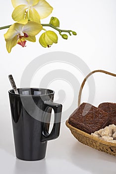 Black coffee cup, chocolate muffins and yellow orchid