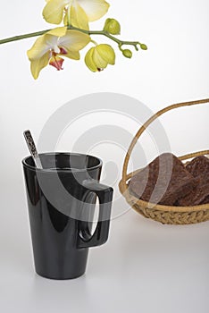 Black coffee cup, chocolate muffins and yellow orchid