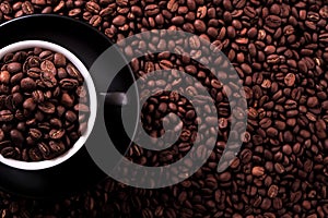 Black coffee cup filled beans background top view