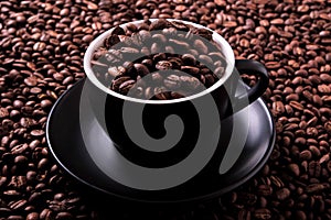 Black coffee cup filled with roasted beans background