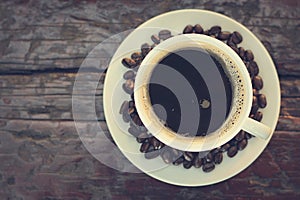 Black coffee in the cup on old wood table (top view)