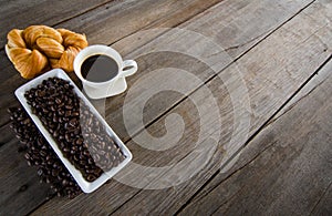 Black coffee cup with stuffed bread on wood