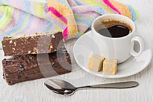 Black coffee in cup, sugar, spoon, chocolate wafer and napkin