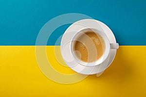Black coffee in a cup on Ukraine flag blue and yellow background