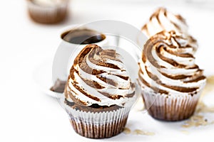 Black coffee with cupcakes and muffins. Spice cupcakes with creamcheese frosting decorated with a cocoa photo