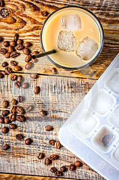 coffee ice cubes and beans with latte on wooden desk background top view