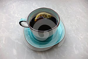 Black coffee with lemon in a blue cup