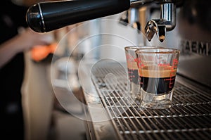 Black coffee in measuring cup put on coffee maker,coffee machine making espresso