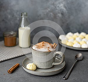 Black coffee with milk and cinnamon, in a gray coffee cup, with meringue