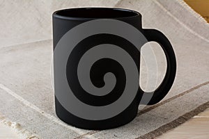 Black coffee mug mockup on the linen napkin