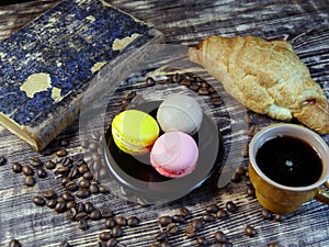 Black coffee and multicolored macarone on vintage background