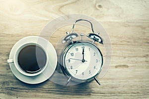 Black coffee Open notebook with old-fashioned alarm clock on woo