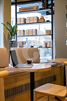 Black coffee and a portable computer on the cafe table