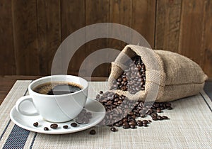 Black coffee and sack of roasted coffee beans.