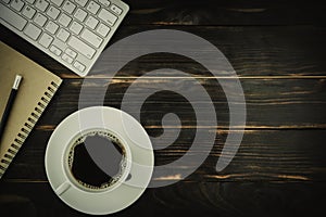 black coffee in a white coffee cup above business home office dark grey wooden table background