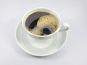 Black coffee in white cup, coffee beans on old wooden texture background.