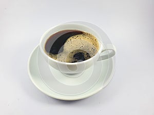 Black coffee in white cup, coffee beans on old wooden texture background.