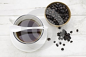 Black coffee in white cup and coffee beans with spoon