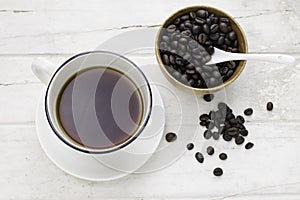 Black coffee in white cup and coffee beans with spoon