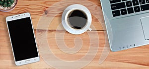 Black coffee in white cup and laptop computer and Mobile Phone or Smartphone with blank screen on wooden floor